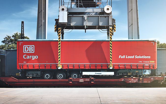 Sattelauflieger wird auf Flachwagen geladen (Seitenansicht)