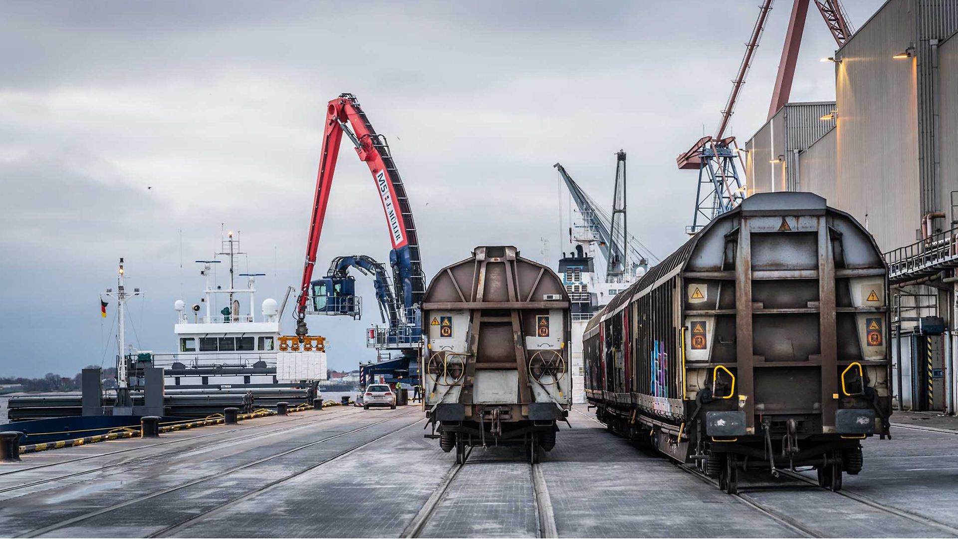 Güter werden vom Schiff auf den Zug geladen.