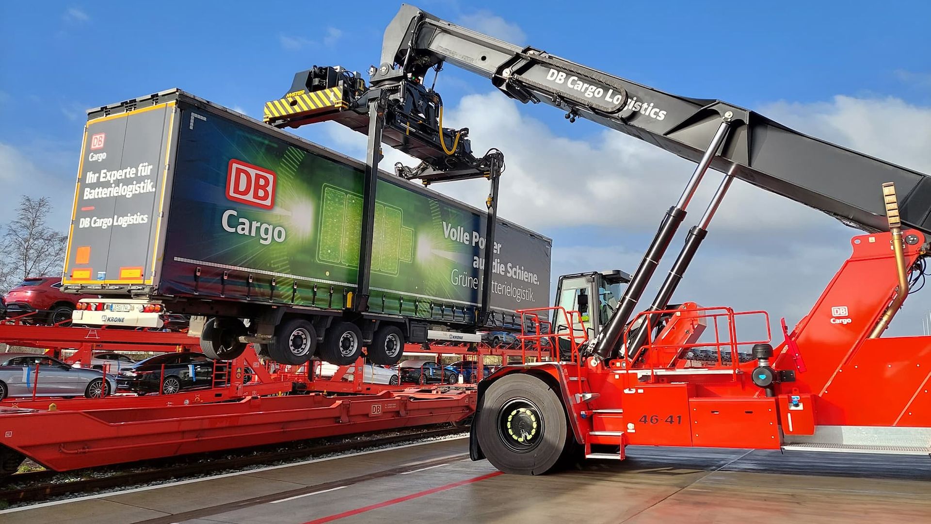 Megatrailer wird von Reachstacker auf einen Taschenwagen verladen