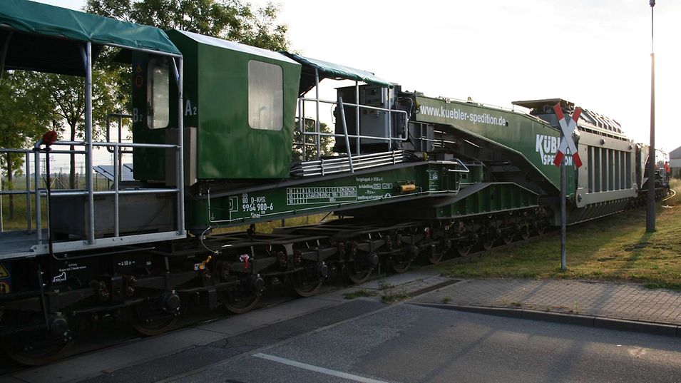 Der hintere Teil des Güterzugs der Transformatorlieferung überfährt einen Bahnübergang.