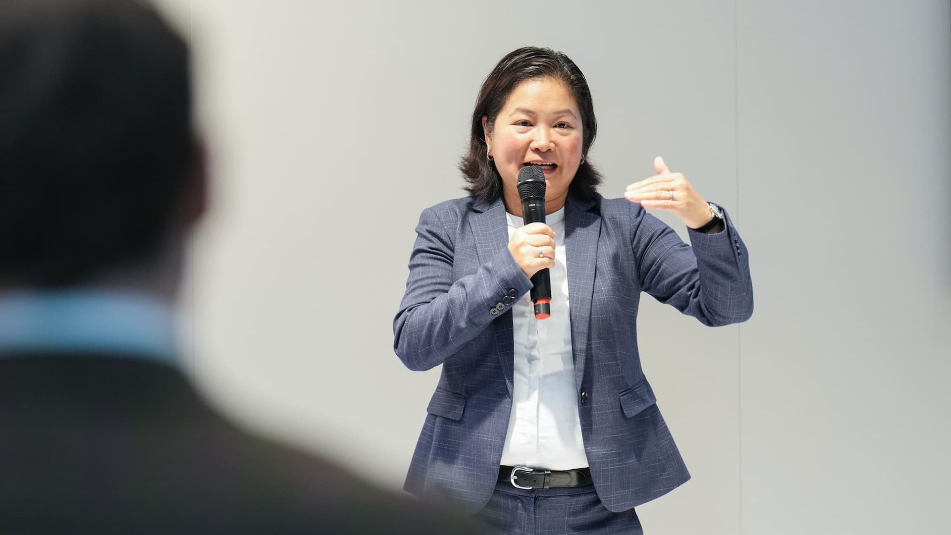 A speaker with a microphone on a stage.