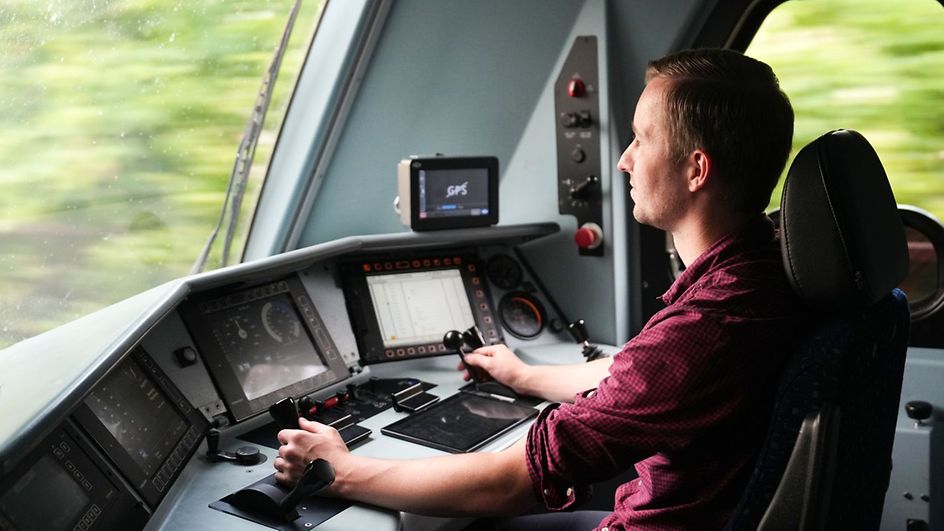 Train driver sits in the cab of a locomotive and drives the train.