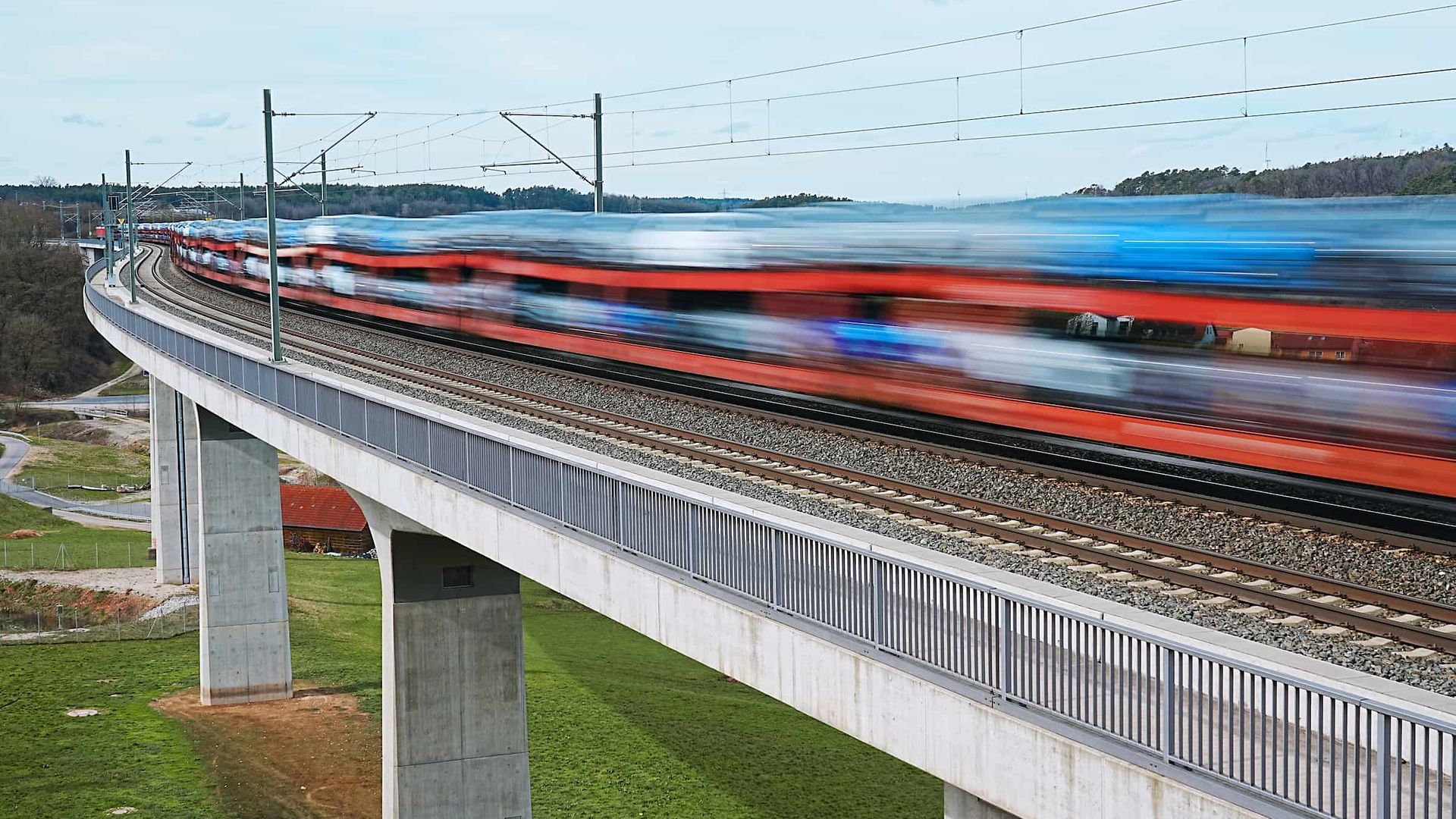 Car transport train crosses bridge