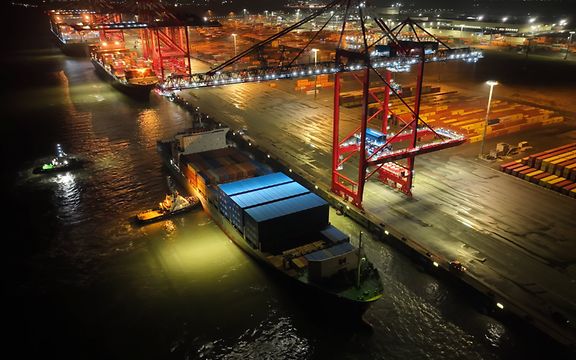 A bird's eye view of a ship loading at JadeWeserPort at night